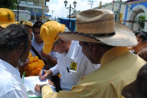 Candidato Jorge De la Vega firmando invitación para asistir a debate.